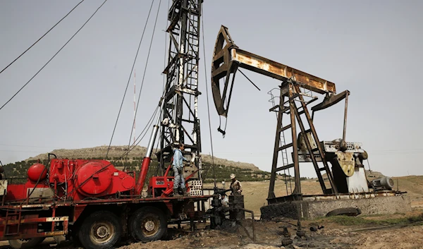 Workers fix pipes at an oil well in an oil field controlled by the US-backed YPG, in Rmeilan, Al-Hasakah province, Syria, March 27, 2018