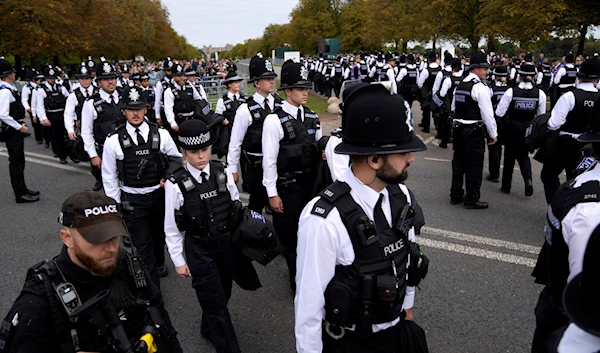 Police gather to take positions as they wait for the arrival of the cortege with the coffin of Queen Elizabeth II outside Windsor Castle in Windsor, England, Monday, Sept. 19, 2022 (AP Photo/Alastair Grant, Pool)