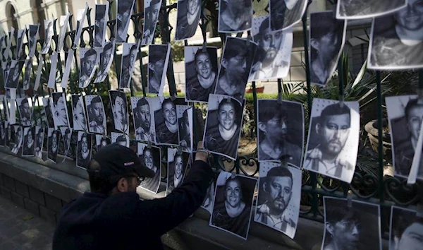 A man hangs images of murdered journalists during a demonstration against the murder of a journalist Anabel Flores outside the Government of Veracruz building in Mexico City, February 11, 2016. (Reuters)