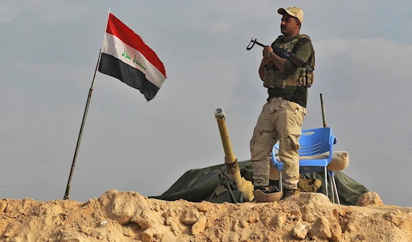 An Iraqi soldier stands guard near the Iraqi city of Qaim at the Iraqi-Syrian border