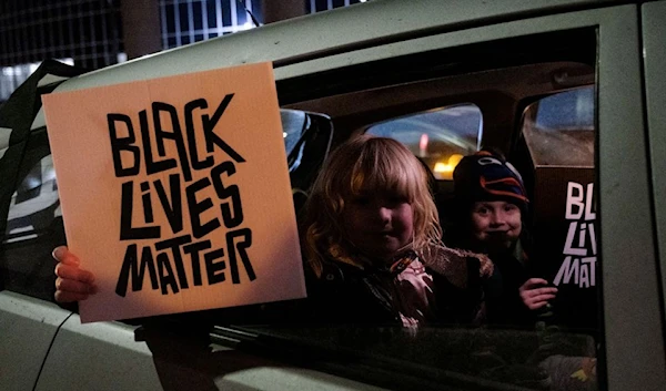 Children hold up Black Lives Matter signs during a protest for Amir Locke in Minneapolis, Minnesota (Reuters)