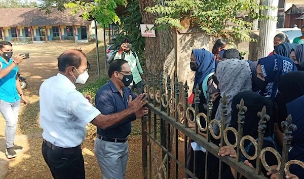 A photo showing hijab-clad students outside a college gate in Karnataka.