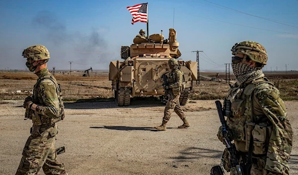 US soldiers walk while on patrol by the Suwaydiyah oil fields in Syria's northeastern Hasakah province on February 13, 2021 (AFP)