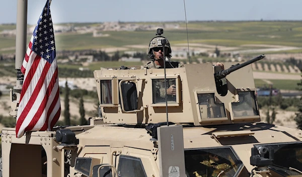 A US soldier sits in an armored vehicle in Manbij, northern Syria (AP)