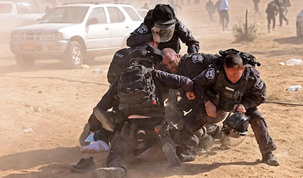 Israeli occupation forces detain a man as Bedouins protest in Al-Naqab Desert against the Jewish National Fund's aspirations to uproot them from their land