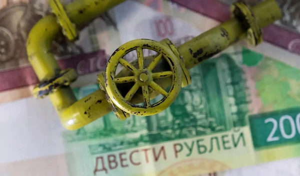 A model of a natural gas pipeline is placed on ruble banknotes (Reuters)