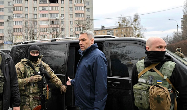 Austrian Chancellor Karl Nehammer with Ukrainian forces after visiting the site of a mass grave in Bucha, Ukraine (AFP)