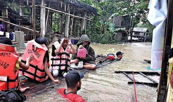 Residents are evacuated by rescuers in a flooded village in Panitan, Panay Island, Philippines. (AP)