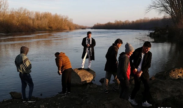 From file: Migrants stand on the banks of Evros river, natural border between Turkey and Greece, near Edirne, Turkey, March 2, 2020. (Reuters)