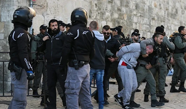 Israeli security assualts a Palestinian elderly from entering e Al Aqsa Mosque to attend prayers (AFP)