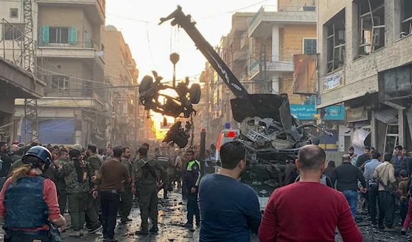 Wreckage of a vehicle is removed after a series of explosions in Qamishli