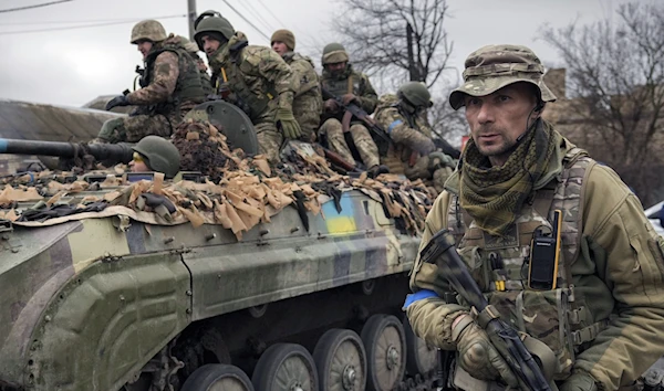 A Ukrainian officer walks alongside a tank, outside Kiev, Ukraine, April 2, 2022 (AP)