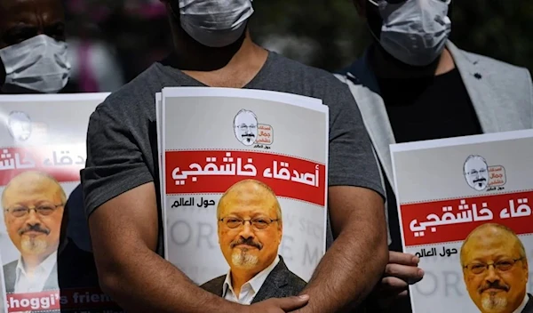 Friends of murdered Saudi journalist Jamal Khashoggi hold posters on October 2, 2020 (AFP)