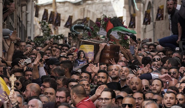 Mourners carry the casket of martyred Palestinian Al Jazeera journalist Shireen Abu Akleh during her funeral in the Old City of Al-Quds, occupied Palestine, Friday, May 13, 2022 (AP)