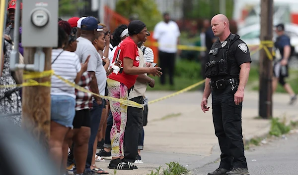 An officer speaks to distressed bystanders near the scene of the mass shooting in Buffalo, New York, United States on May 14, 2022 (AP)