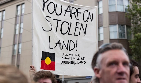 Protesters hold placards during a protest organised by Aboriginal rights activists on Australia Day in Melbourne, Australia (Anadolu Agency)