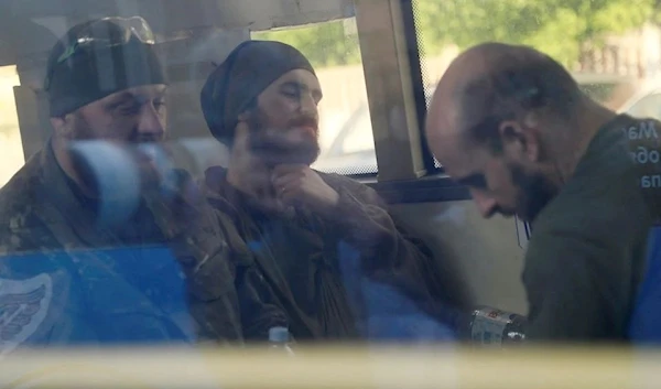 Ukrainian fighters who have surrendered after weeks of being sieged at the Azovstal steel plant are seen inside a bus, Mariupol May 17, 2022 (Reuters)