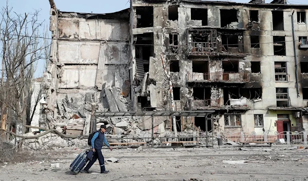 A man walks past a destroyed residential building, Mariupol, Ukraine April 17, 2022 (Reuters)