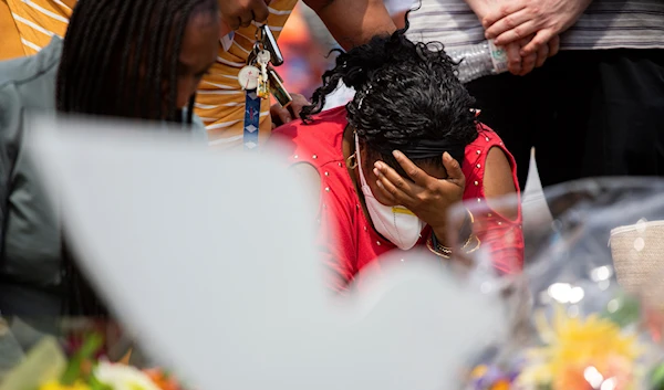 A woman mourns during a moment of silence for the victims of the Buffalo supermarket shooting outside the Tops Friendly Market on Saturday, May 21, 2022, in Buffalo, New York (AP)