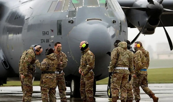 US soldiers are seen in front of C-130 transport plane during a military drill at Yokota US Air Force Base in Fussa (Reuters)