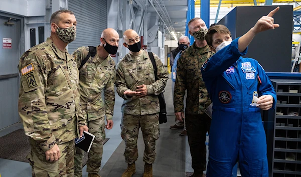 US army officers and a NASA astronaut at the Space Vehicle Mockup Facility at Johnson Space Center in Houston, Texas