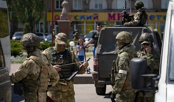 Russian soldiers patrol a street in Melitopol on May 1, 2022