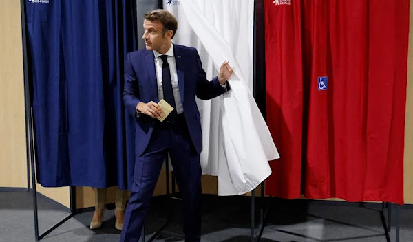 Emmanuel Macron leaves the voting booth in the first round of French parliamentary elections, June 12, 2022 (AP)