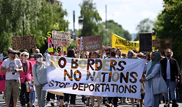 Protesters demonstrating outside an airport perimeter fence against the planned deportation of asylum seekers from the UK to Rwanda, June 12, 2022, Gatwick Airport, Crawley, United Kingdom (Toby Melville/Reuters)