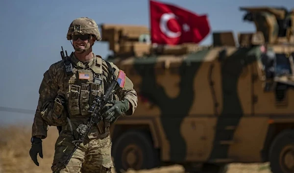 A US soldier stands guard during a joint patrol with Turkish troops in the Syrian village of al-Hashisha on the outskirts of Tal Abyad on 8 September, 2019 (AFP)