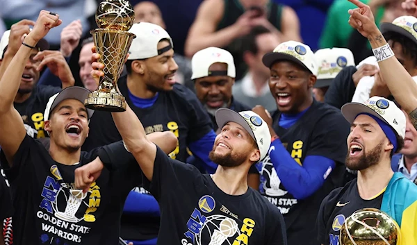 Stephen Curry, 30 of the Golden State Warriors, raises the Bill Russell NBA Finals Most Valuable Player Award.