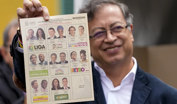 Gustavo Petro, a presidential candidate with the Historical Pact coalition, shows his ballot before voting during presidential elections in Bogota, Colombia, Sunday, May 29, 2022 (AP)