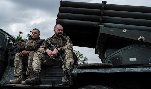 Ukrainian soldiers ride on a moving truck-mounted multiple rocket launcher near Lisichansk on May 13, 2022