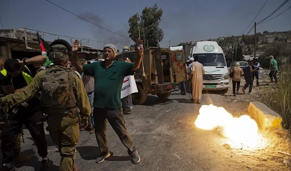 A sound grenade is fired by Israeli forces during a protest against the creation of a new road for Israeli settlers, near the Palestinian village of Beita, north of the West Bank, Nablus, August 25, 2021 (AP)