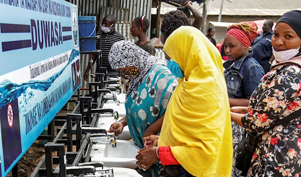 People use a hand-washing station installed for members of the public entering a market in Dodoma, Tanzania, May 18, 2020 (AP)