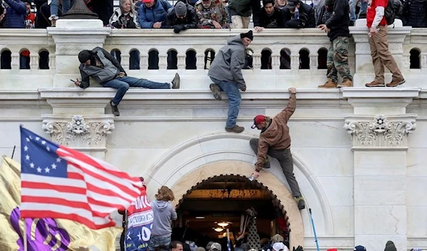 A mob of supporters of former U.S. President Donald Trump fight with members of law enforcement at a door they broke open as they storm the U.S. Capitol Building in Washington, U.S., January 6, 2021. (Reuters)