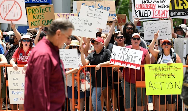 Protestors yell at a man leaving the NRA convention in Houston, Texas, on May 27, 2022 (Los Angeles Times)