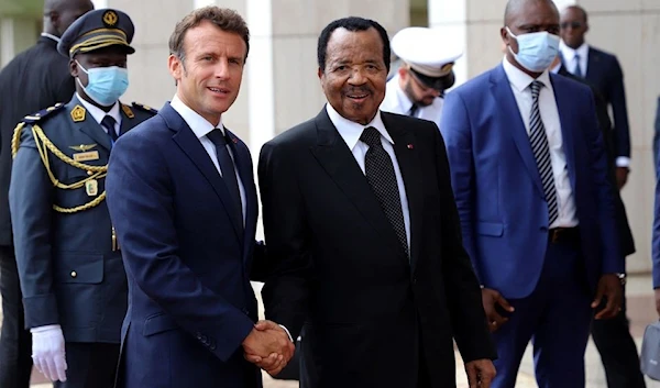 Cameroonian President Paul Biya shakes hands with his French counterpart Emmanuel Macron at the presidential palace in Yaounde, Cameroon, July 26, 2022 (Reuters)