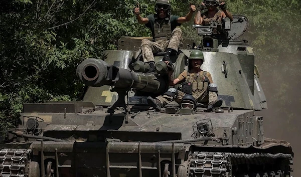 Ukrainian troops ride a self-propelled howitzer in the Donetsk People's Republic, Ukraine July 8, 2022 (Reuters)