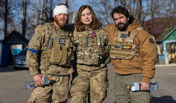 Red Taylor, Alexis Antilla and Rob, members of a group of U.S. volunteer fighters who have taken up arms alongside Ukrainian soldiers, stand in front of a hospital in the town of Brovary, near Kyiv, Ukraine, March 20, 2022.