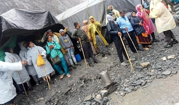 People stand outside tents after a cloudburst near the holy Amarnath cave shrine in Kashmir (Reuters)