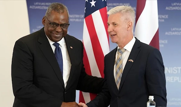 U.S. Secretary of Defense Lloyd Austin, left, and Latvian Minister of Defence Artis Pabriks shake hands during the press conference in Riga, Latvia, Wednesday, August 10, 2022. (AP)