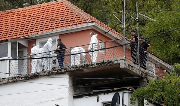 Police forensic team inspect the house where a gunman started a mass shooting in which 11 people were killed. (Reuters)