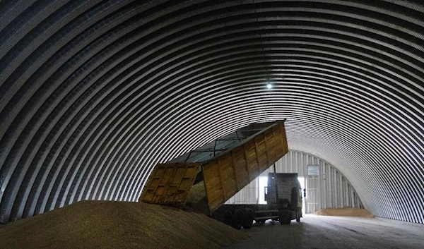 An employee unloads wheat grains inside a storage in the village of Zghurivka, amid Russia's attack on Ukraine, in Kyiv region, Ukraine on August 9, 2022. Photo by Viacheslav Musiienko/Reuters