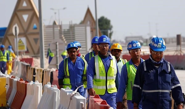 Workers walk towards the construction site of the Lusail Stadium during a stadium tour in Doha, Qatar, December 20, 2019 (Reuters)