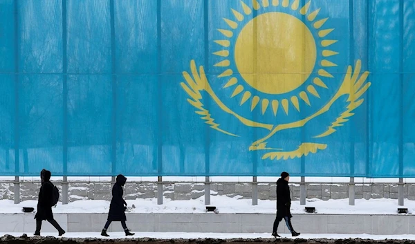 People walk past a gaint Kazakhstan flag in Astana, Kazakhstan March 5, 2019. (Reuters)