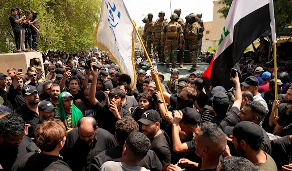 Supporters of Muqtada al-Sadr surround a vehicle with soldiers during a protest in front the Supreme Judicial Council, in Baghdad, Iraq, Tuesday, Aug. 23, 2022 (AP Photo/Hadi Mizban)