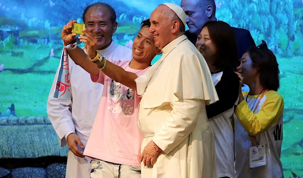 Pope Francis poses for a selfie during a meeting with youth in his trip to South Korea in 2014 (AP)