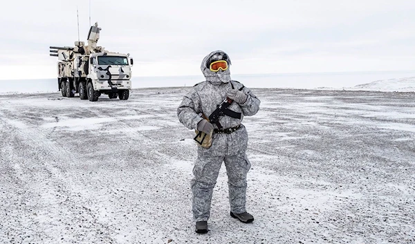 A soldier holds a machine gun as he patrols the Russian northern military base on Kotelny island, beyond the Arctic circle on April 3, 2019.