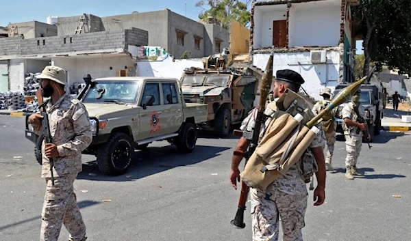 Members of the "444 Brigade" affiliated with Libya's Ministry of Defence man positions in the area of an overnight gunbattle in Tripoli's suburb of Ain Zara, on July 22, 2022. (AFP)