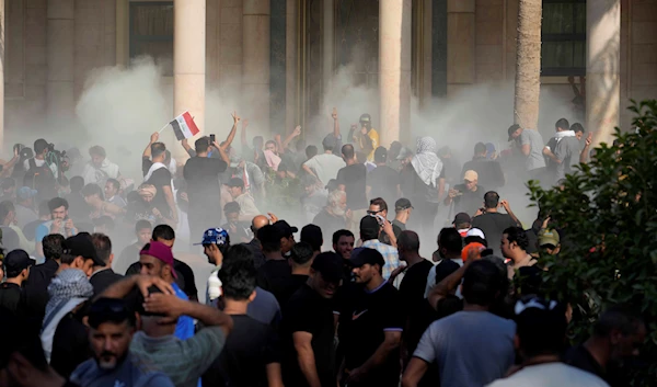 Iraqi security forces fire tear gas on the followers of Shiite cleric Muqtada al-Sadr inside the government Palace, Baghdad, Iraq, Monday, Aug. 29, 2022 (AP Photo/Hadi Mizban)